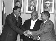 FILLING SHOES: MEC Zweli Mkhize, left, was sworn in as KwaZulu-Natal acting premier yesterday while Premier Sbu Ndebele, right, is on an official ANC trip to Namibia. Officiating at the swearing - in ceremony was provincial judge president Vuka Tshabalala. © Unknown.