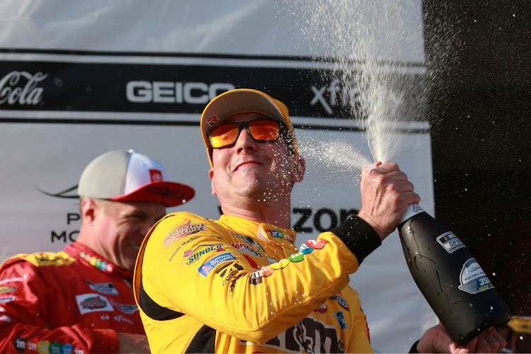 Kyle Busch celebrates after winning the NASCAR Cup Series Explore the Pocono Mountains 350 at Pocono Raceway on June 27 2021 in Long Pond, Pennsylvania.