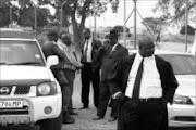 SO LONG: Lawyer Mpho Mashiloane wlks away from a group of policers from the Mpumalanga police's organised crime unit. He abandoned his clients in muti murder bail application because members of the community have threatened him. Pic. Riot Hlatshwayo. 11/09/2008. © Sowetan.