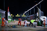 rack marshals clear water from the track prior to the F1 Grand Prix of Singapore at Marina Bay Street Circuit on October 02, 2022 in Singapore, Singapore.