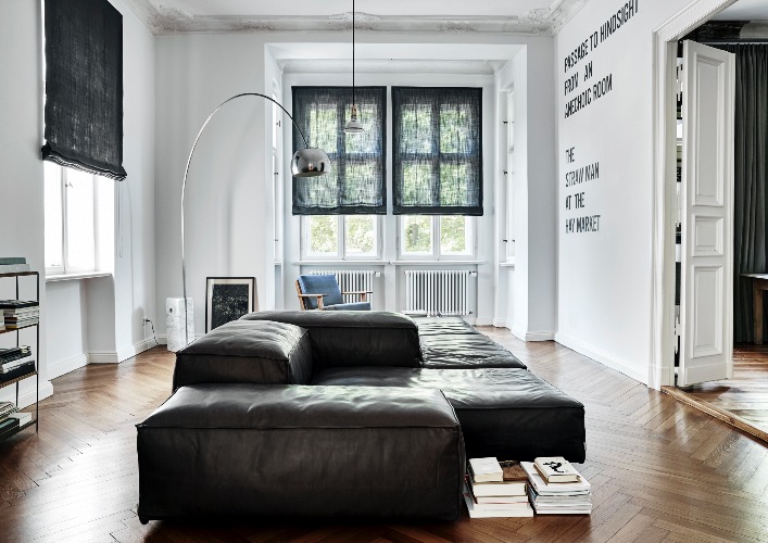 The spacious, sun-drenched living room. The walls have been kept white to invoke a fresh feeling as well as to highlight the original 19th century moulded cornices. Stonewashed French linen window coverings are simple but effective in gently filtering the light when necessary. The parquet flooring, like the architectural mouldings, are original features.