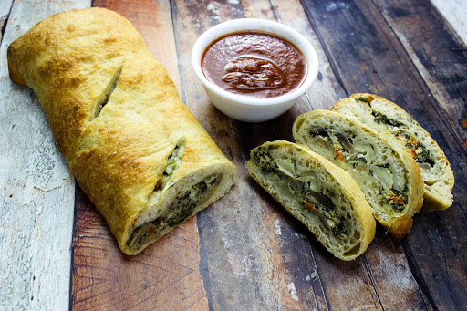 Slices of Alfredo Stromboli with dipping sauce.