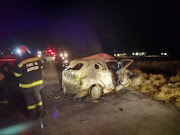 A woman trapped in her burning vehicle died after a collision with a truck.