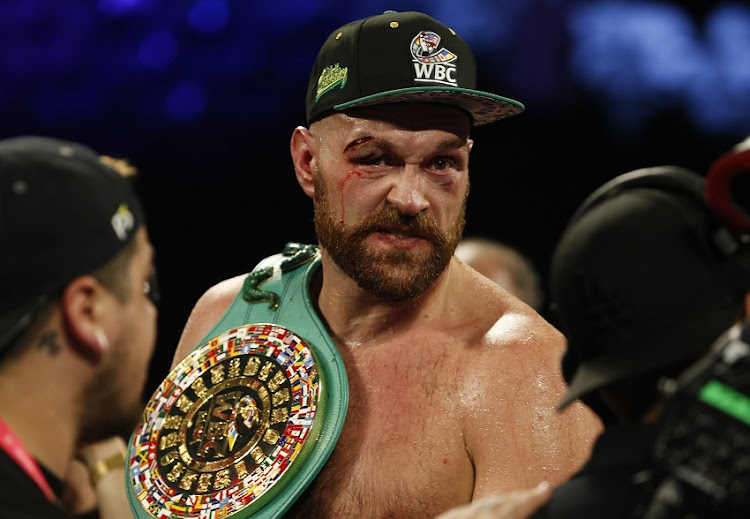 Tyson Fury holds the lineal heavyweight belt as he celebrates victory after the fight.