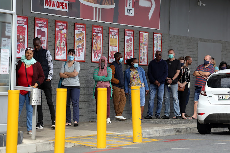 Shoppers waiting their turn to buy supplies at OK in Cambridge over the weekend.