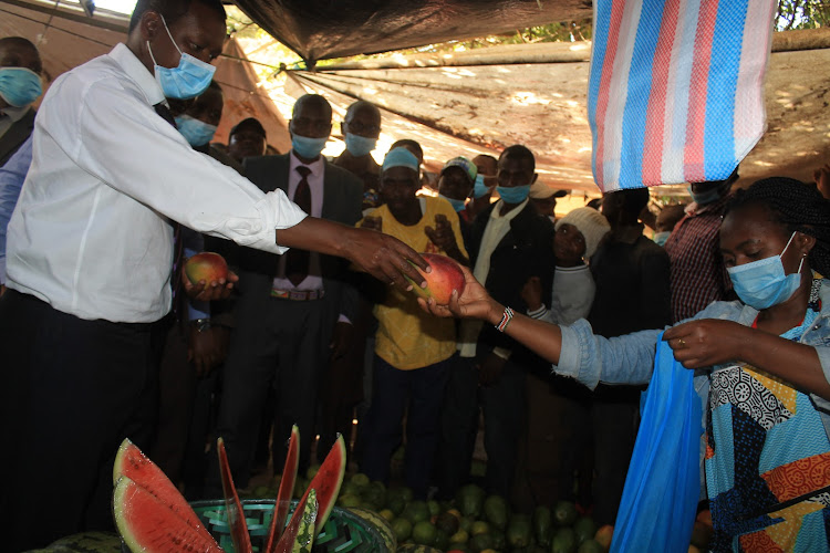 Governor Alfred Mutua interacts with traders at Machakos open air market on Tuesday, February 16.