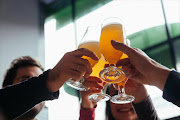 A crowd of friends enjoying beers at a bar.