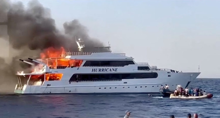 A rescue boat sails beside as plumes of smoke erupt from a yacht on fire in Marsa Alam, Egypt, June 11, 2023 in this screengrab taken from a handout video.