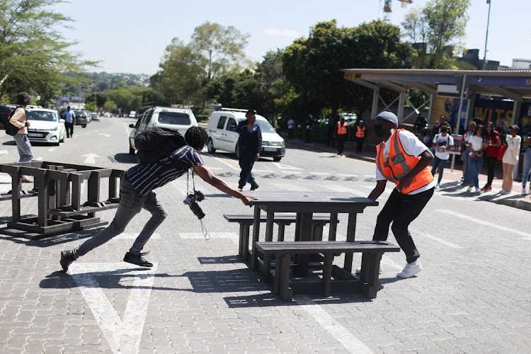 A protesting student blocks a road with benches at the University of the Witwatersrand in Johannesburg on March 2 2023.