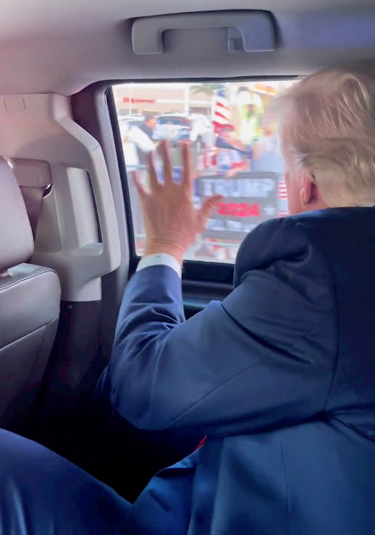 Former U.S. president Donald Trump waves to a crowd en route to his to his Mar-a-Lago resort, after being indicted by a Manhattan grand jury following a probe into hush money paid to porn star Stormy Daniels, in Palm Beach, Florida, U.S., April 4 2023 in this still image from social media video.