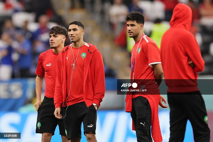 Morocco's forward #16 Abde Ezzalzouli (L), Morocco's defender #02 Achraf Hakimi and Morocco's goalkeeper #12 Munir El Kajoui inspect the pitch ahead of the Qatar 2022 World Cup semi-final football match between France and Morocco at the Al-Bayt Stadium in Al Khor, north of Doha on December 14, 2022. (Photo by KARIM JAAFAR / AFP)