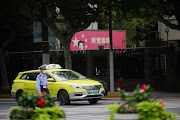 A security guard wearing a mask walks past a portrait of Chinese President Xi Jinping on a street, following the coronavirus disease (Covid-19) outbreak, in Shanghai, China, August 31, 2022. 