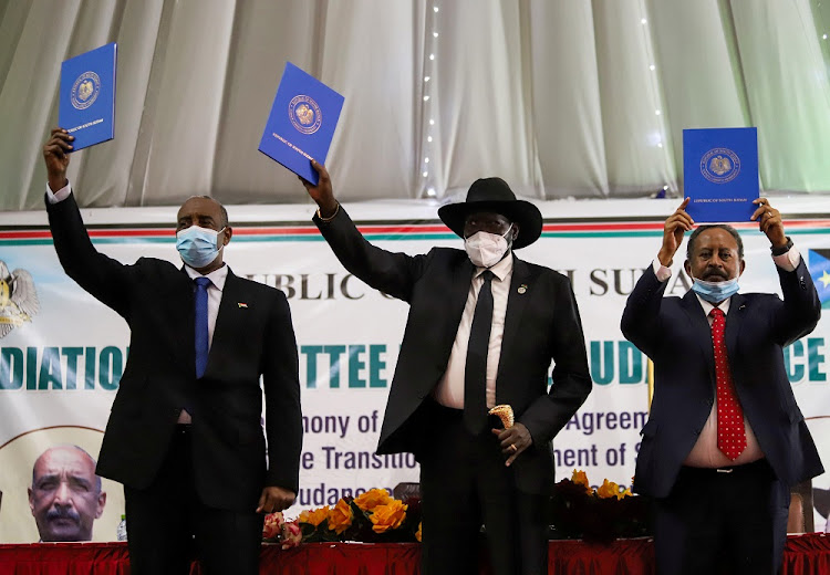 Sudan's Sovereign Council Chief General Abdel Fattah al-Burhan, South Sudan's President Salva Kiir, and Sudan's Prime Minister Abdalla Hamdok lift copies of a signed peace agreement with the country's five key rebel groups, a significant step towards resolving deep-rooted conflicts that raged under former leader Omar al-Bashir, in Juba, South Sudan August 31, 2020.