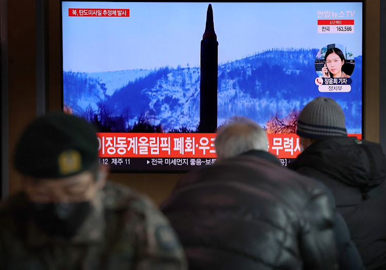 People watch a TV broadcasting file footage of a news report on North Korea firing what appeared to be a ballistic missile, in Seoul, South Korea, February 27, 2022.