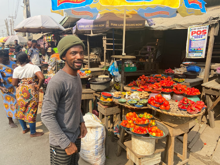 Nigerian artist Olufela Omokeko buys fresh peppers at a food market in Lagos.