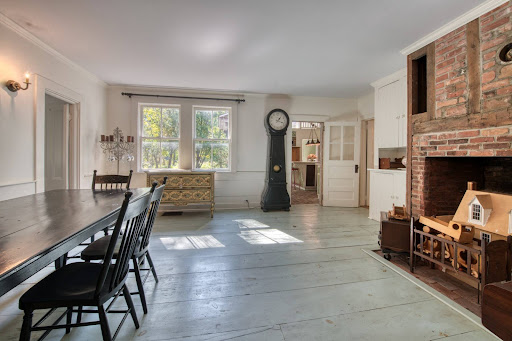 Dining room with antique wood floor and fireplace in this luxury house for sale in Greenport ($1,250,000)