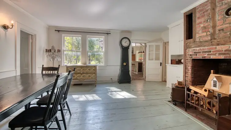 Dining room with antique wood floor and fireplace in this luxury house for sale in Greenport ($1,250,000)