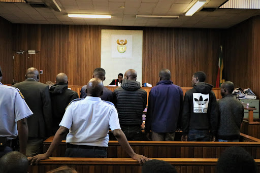 Six of the eight men accused of stealing R20m in the OR Tambo heist in court. (File photo)