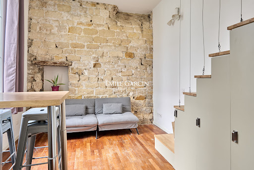 Luxury property for sale in Paris 9ème (75009) - Living room with stone wall and grey sofa
