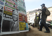 People walk past a newspaper stand a day after the death of Ivory Coast's Prime Minister Hamed Bakayoko, in Abidjan, Ivory Coast on March 11, 2021. The newspaper title (L) reads 