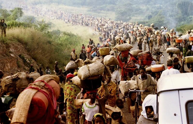 Rwandan refugees cross Rusumo border to Tanzania from Rwanda May 30, 1994 carrying their belongings even goats, mattresses and cows. REUTERS/Jeremiah Kamau/File Photo