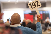 A bidder raises his paddle at the Cape Fine & rare Wine Auction in Stellenbosch on Saturday.