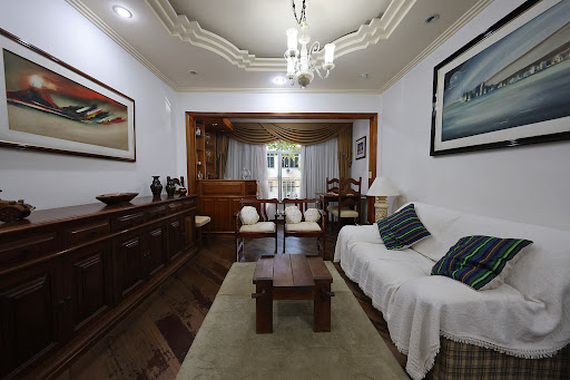 Living room with white sofa and wood sideboard in this luxury property for sale in Rio de Janeiro ($404,523 - 85 m²)