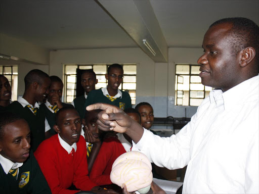 A teacher takes his students through a lesson at a school in Nairobi. /FILE
