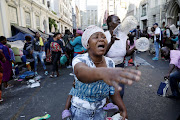 A woman reacts as law-enforcement officers remove refugees from the Cape Town CBD.