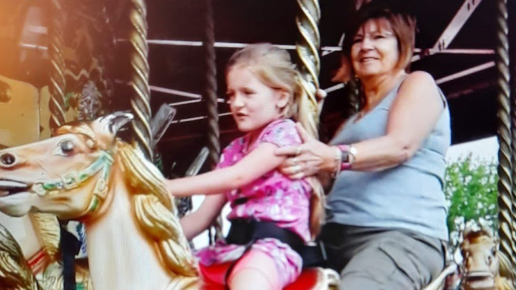 Julie Smith and her granddaughter on the carousel on their family trip