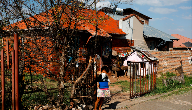 A little girl watching over while Vrededorp residents receive cooked meals organised by a charity on day 50 of the Covid-19 lockdown on May 15 2020.