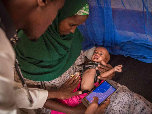 Dr Siyad Hassan checks the breathing rate of five-month-old pneumonia patient Khadija at Griftu sub-county hospital in Wajir, July 28, 2017. /JONATHAN HYAMS/SAVE THE CHILDREN