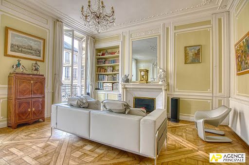 Prestige property for sale in Versailles (78000) - Neighborhood Saint Louis - Living room with white sofa, fireplace and bookshelf