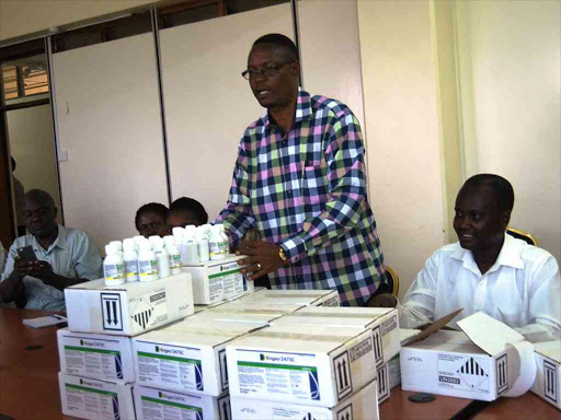 Kisumu county agriculture cabinet secretary Henry Obade inspects the pesticide purchased to fight the destructive army worms that have invaded farms in the area.MAURICE ALAL.