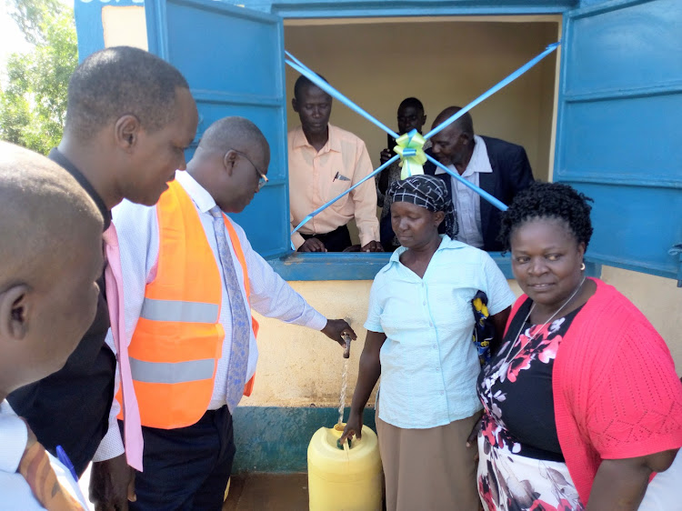 Siaya Governor Cornel Rasanga commissions a water project on Wednesday. Looking on are Water executive Adrian Ouma, South Sakwa MCA Lorn Adida and residents