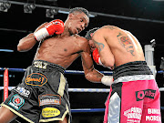 Thulani Mbenge, left, digs a left uppercut on Diego Chaves. Mbenge says being in the ring completes him. /  n-squared  Delme Thomas