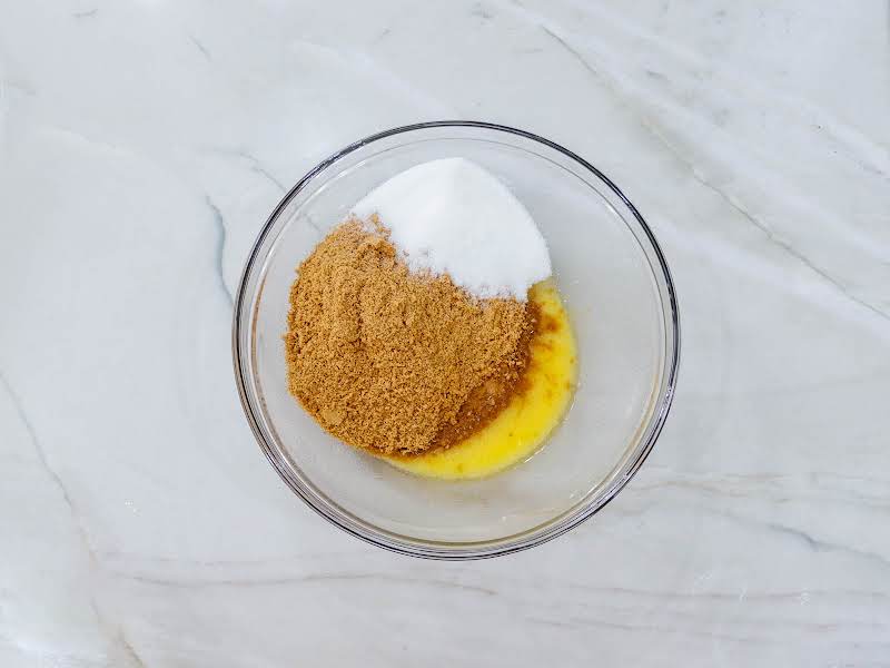 Crushed Graham Crackers, Melted Margarine, And Sugar In A Bowl.