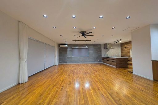 Modern living room with wooden floor and open kitchen in this luxury property for sale in Ishigaki ($673,769)