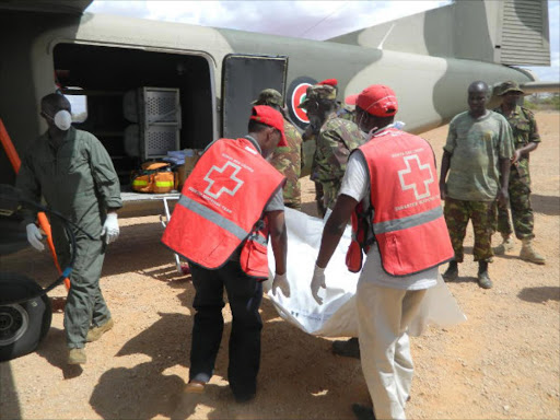 Kenya red cross officials load bodies of the victims of Mandera attack into the millitary chopper at the mandera airstrip