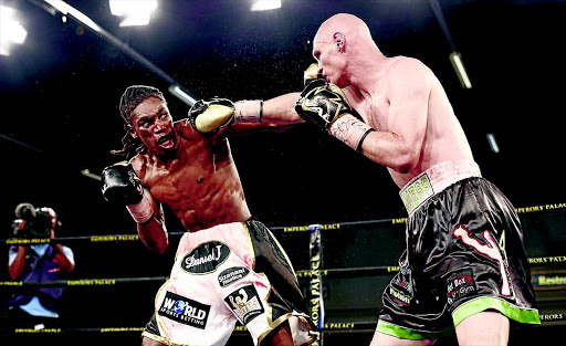 Thulani Mbenge exchanges blows with Shaun Ness in a fight which Mbenge won by a seventh round stoppage to be crowned the new SA welterweight champion at Emperors Palace on Sunday. /Nick Lourens