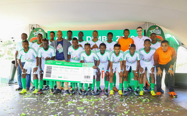 Safaricom Chief Corporate Affairs Officer Stephen Chege (in blazer) with the Chapa Dimba All Stars male team during the teams unveil at Ligi Ndogo before the teams’ trip to Spain. With the team is Oliver Dodd, Laliga Representative in Kenya.