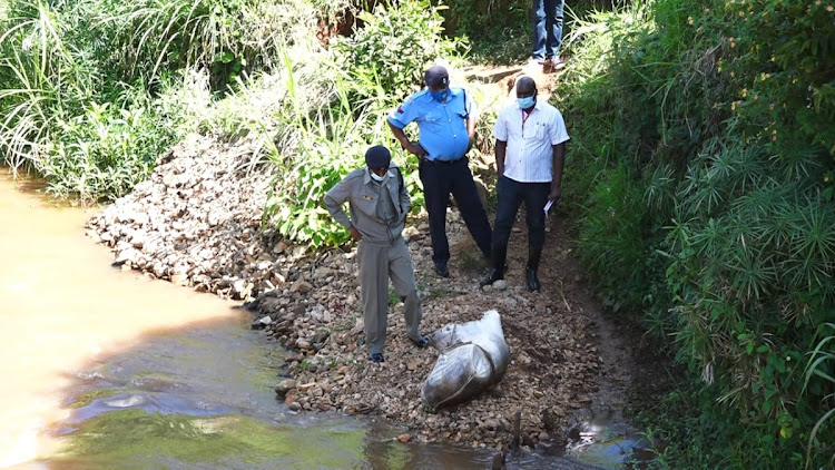 Police at Mathioya river where a body was found dumped in a gunny bag.