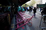 Sails of the landmark red windmill atop the Moulin Rouge, Paris's most famous cabaret club, are seen on the ground after they fell off during the night in Paris, France, on April 25 2024. 