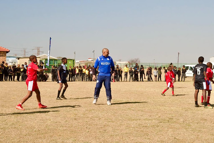 Former Bafana winger Delron Buckley playing with pupils of Tsholetsega primary school after donating kits and food hampers on Monday.