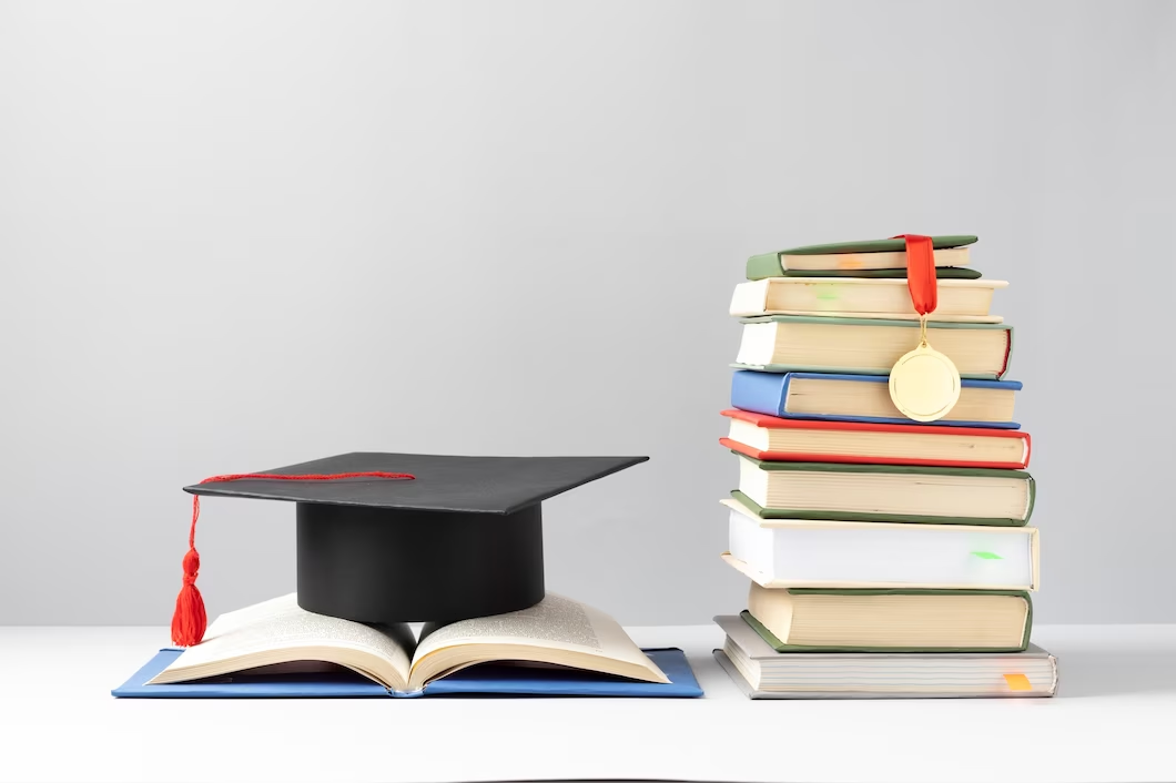 Stacked books and graduation cap symbolising passing in the BCAT.