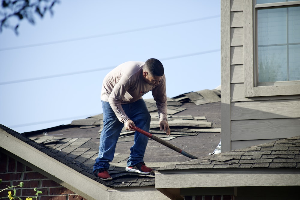 a man with a hammer on top of a roof