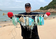 Gary Stokes, co-founder of marine conservation group OceansAsia, shows face masks that washed up on the beach of Soko Islands, following an outbreak of the novel coronavirus, in Hong Kong, China March 7, 2020.