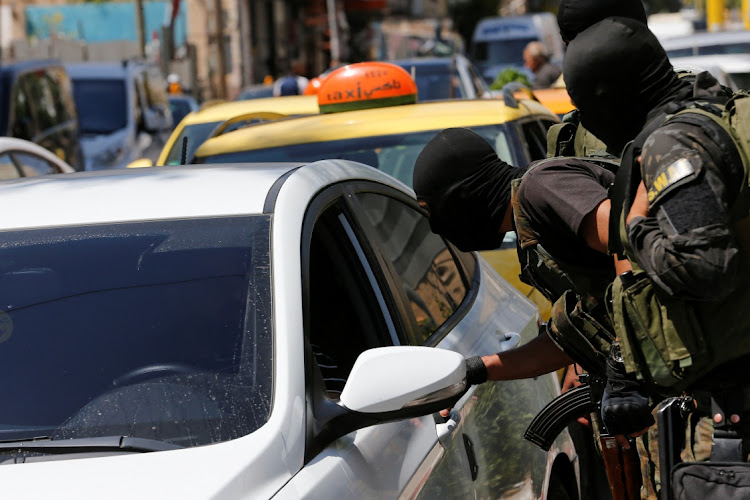 Members of Palestinian security forces check cars amid protests over rising prices, in Hebron, in the Israeli-occupied West Bank, June 6, 2022.