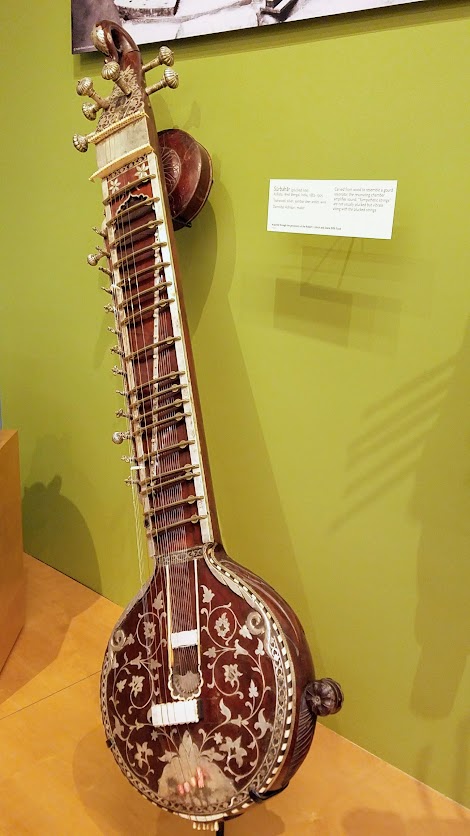 Music Instrument Museum (MIM) Geographic galleries, Surbahar, plucked lute from India; tealwood, silver, sambar deer antler, wire. Carved from wood to resemble a gourd resonate, the resonating chamber amplifies sound and sympathetic strings are not usually plucked but vibrate along with plucked strings