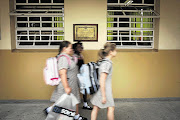 School girls walk past a classroom. File photo.